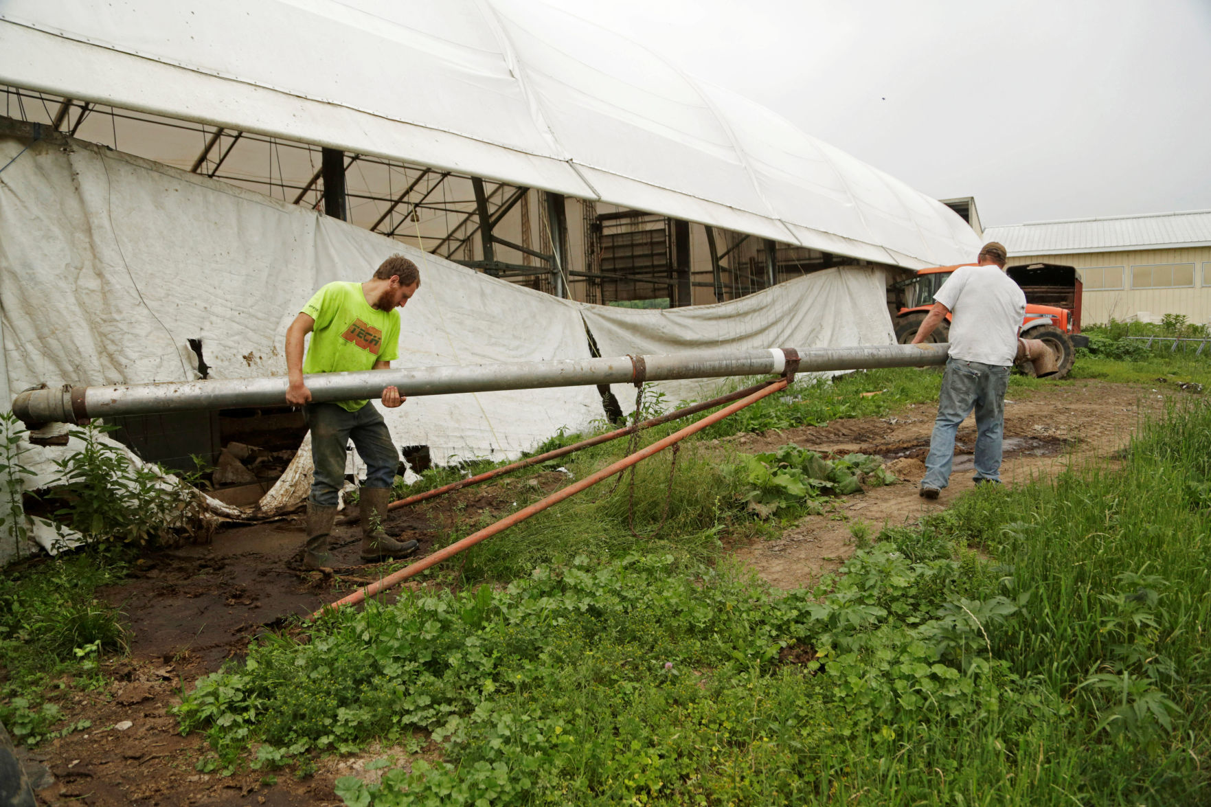 Gordon A. Giese and his son Paul Giese get ready to fill a manure tank at the family farm, God Green Acres in Mayville